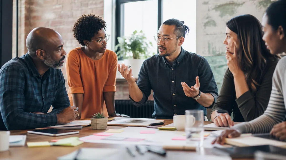 Soft skills en action : une équipe échange autour d'une table de travail