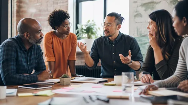 Équipe qui échange autour d'une table couverte de notes